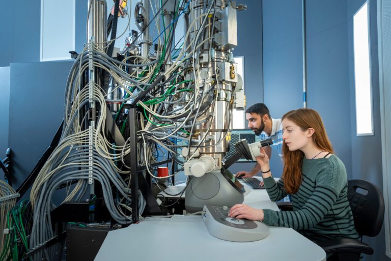 Researchers working on a large piece of machinery