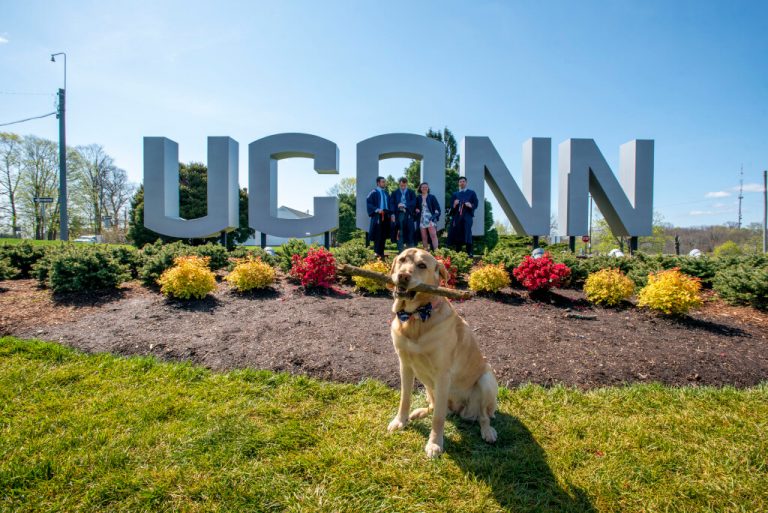 UConn sign with graduates and Officer Tildy (dog)