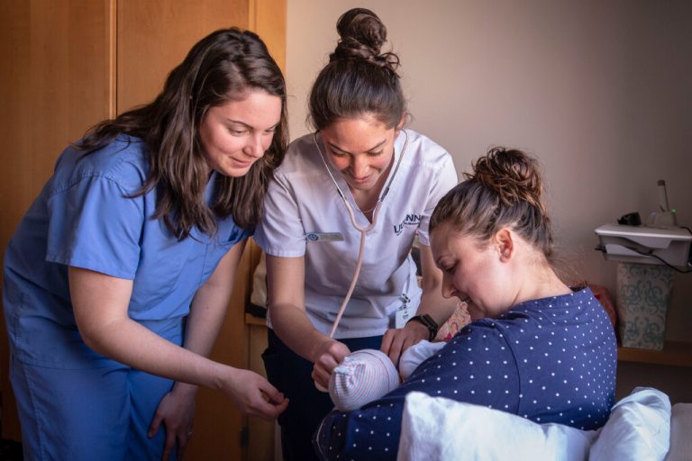 Nurses taking care of newborn baby and mother